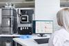 Scientist monitoring Waters Xevo TQ Absolute mass spectrometer and Acquity UPLC system with real-time data on a computer screen